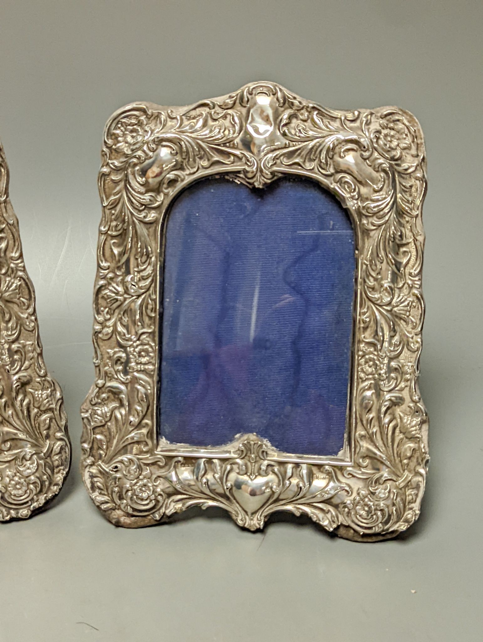 A pair of Edwardian repousse silver mounted photograph frames, Sydney & Co, Birmingham, 1902, 22.5cm (a.f.).